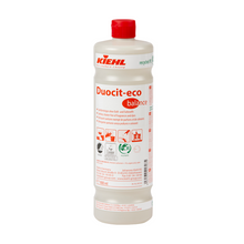 Een 1-liter kunststof fles Johannes Kiehl KG Kiehl Duocit-eco balance sanitairreiniger zonder geur- en kleurstoffen met rode dop en wit etiket met rode en zwarte productinformatie, symbolen en toepassingsinstructies.