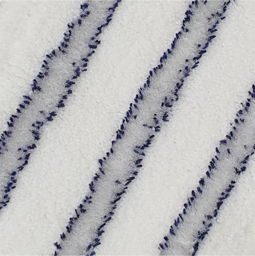 Close-up van de Arcora EXCELLENT SOFT MOPP BLAUW-WIT van Arcora International GmbH: Op het witte, gestructureerde oppervlak zorgen drie gelijkmatig verdeelde, licht verhoogde diagonale lijnen in donker- en lichtblauwe, zachte vezels voor een hoogwaardige afwerking.