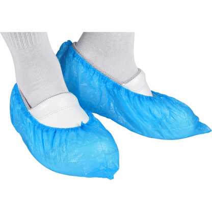 Een persoon draagt witte schoenen en sokken met blauwe uitloopartikelen: Thor overschoenen (41x15 cm, PE, Abena Re-Seller GmbH) over de schoenen en staat voor een witte achtergrond.