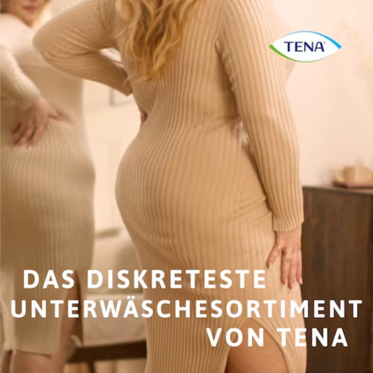 Eine Person in einem beigen Rippenkleid steht vor einem Spiegel, der die Rückansicht mit dem Text „DAS DISKRETESTE UNTERWÄSCHE-SORTIMENT VON TENA“ zeigt und diskrete Unterwäsche für Blasenschwäche betont. Das TENA-Logo befindet sich in der Ecke und präsentiert ihre Silhouette Plus Creme Inkontinenzpants von Essity Germany GmbH.