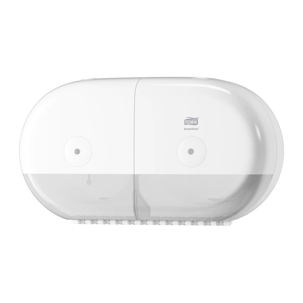 Aan de muur is een Tork SmartOne® 682000 Mini Dubbelrolhouder gemonteerd, vervaardigd door TORK – Essity Professional Hygiene Germany GmbH. Deze witte, ovale houder beschikt over een transparant onderste deel en is met zijn gladde, moderne uitstraling speciaal ontworpen voor het opnemen van dubbelrollen toiletpapier.