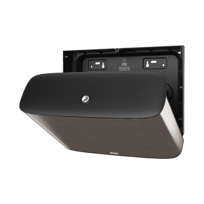 Wij presenteren de Tork Xpress® 460006, een wandgemonteerde dispenser uit de Image Line T2. Met zijn eenvoudige zwarte ontwerp presenteert deze Mini-Jumbo-toiletpapierdispenser van TORK – Essity Professional Hygiene Germany GmbH zich in een elegant roestvrijstalen design. De achterwand met de bevestigingsgaten is zichtbaar en geeft aan dat hij klaar is voor installatie.