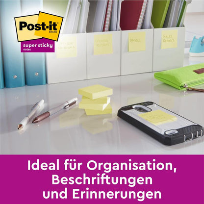 Een bureau met pennen, een smartphone, gestapelde Post-it® Super Sticky Notes (76 mm x 127 mm, 90 vel/blok, 100% PEFC) van 3M Deutschland GmbH en met notities gelabelde mappen. Duitse tekst: "Ideaal voor organisatie, labels en herinneringen.