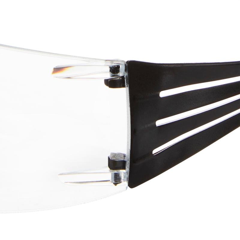 Close-up van de 3M™ SecureFit™ leesbeschermingsbril van 3M Deutschland GmbH. Deze toont de heldere lens en de zwarte poot met drie parallelle sleuven en het zichtbare scharnier dat de poot met de lens verbindt.