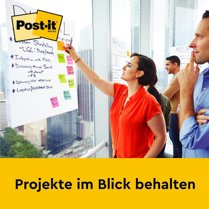 Een vrouw schrijft op een Post-it® Super Sticky zelfklevende vergaderblok (58,4 x 50,8 cm, 20 vellen) van 3M Deutschland GmbH, dat aan een kantoorwand is gemonteerd. Twee personen staan ernaast. Onderaan staat: "Projecten in het oog houden."