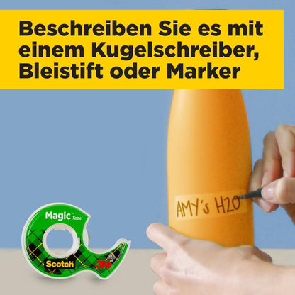 Een hand labelt een oranje fles met een zwarte marker als "AMY'S H2O", terwijl op de voorgrond het Scotch® Magic™ Onzichtbare Plakband (2 rollen, 19 mm x 7,5 m + 1 gratis handdispenser) van 3M Deutschland GmbH te zien is.