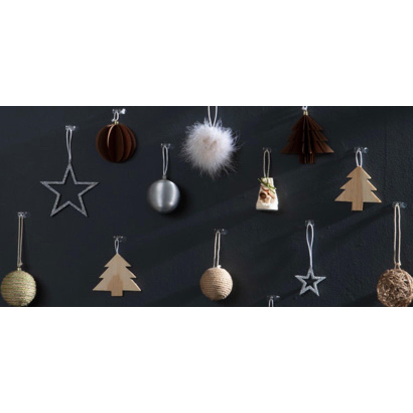 Kerstversiering - sterren, bomen, ballen en een pluizige witte decoratie van hout, metaal, touw en stof - hangen aan een donkere muur met Command™ decoratieclips (transparant) van 3M Deutschland GmbH.
