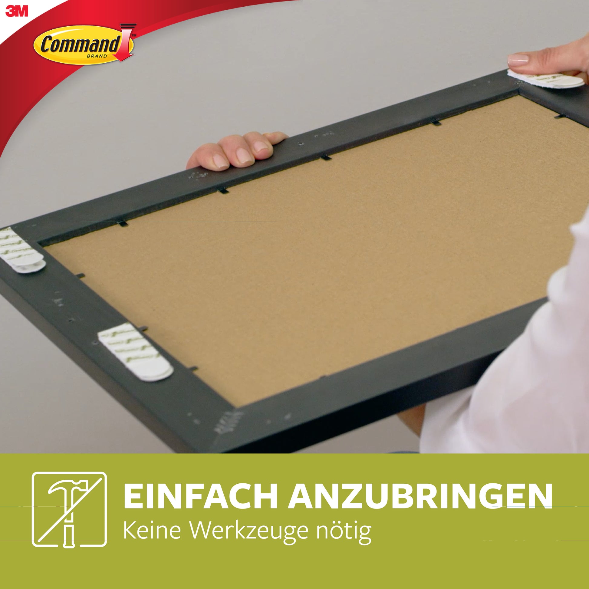 Eine Person hält eine kleine und mittelgroße Command™ Bilder-Montage Strip-Packung (17203) von 3M Deutschland GmbH, befestigt am Bilderrahmen. Text: "EINFACH ANZUBRINGEN Keine Werkzeuge nötig." 3M Command Logo sichtbar.