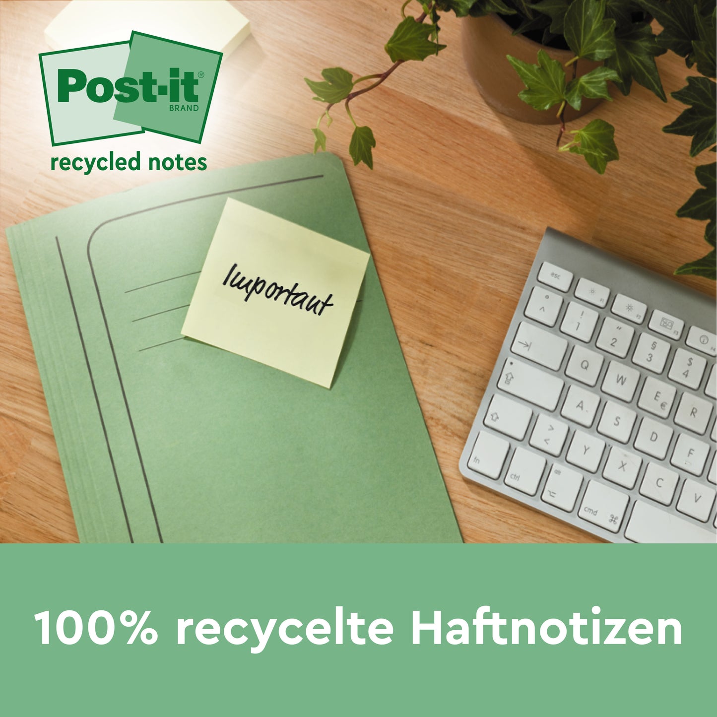 Ein grüner Ordner mit einem gelben Post-it® Recycling Notes, Gelb, 76x127mm, 100 Blatt/Block von 3M Deutschland GmbH liegt auf einem Holzschreibtisch neben einer weißen Tastatur und einer Pflanze. Die Zettel sind 100% PEFC (SGSCH-PEFC-COC-110078) und umweltfreundlich.