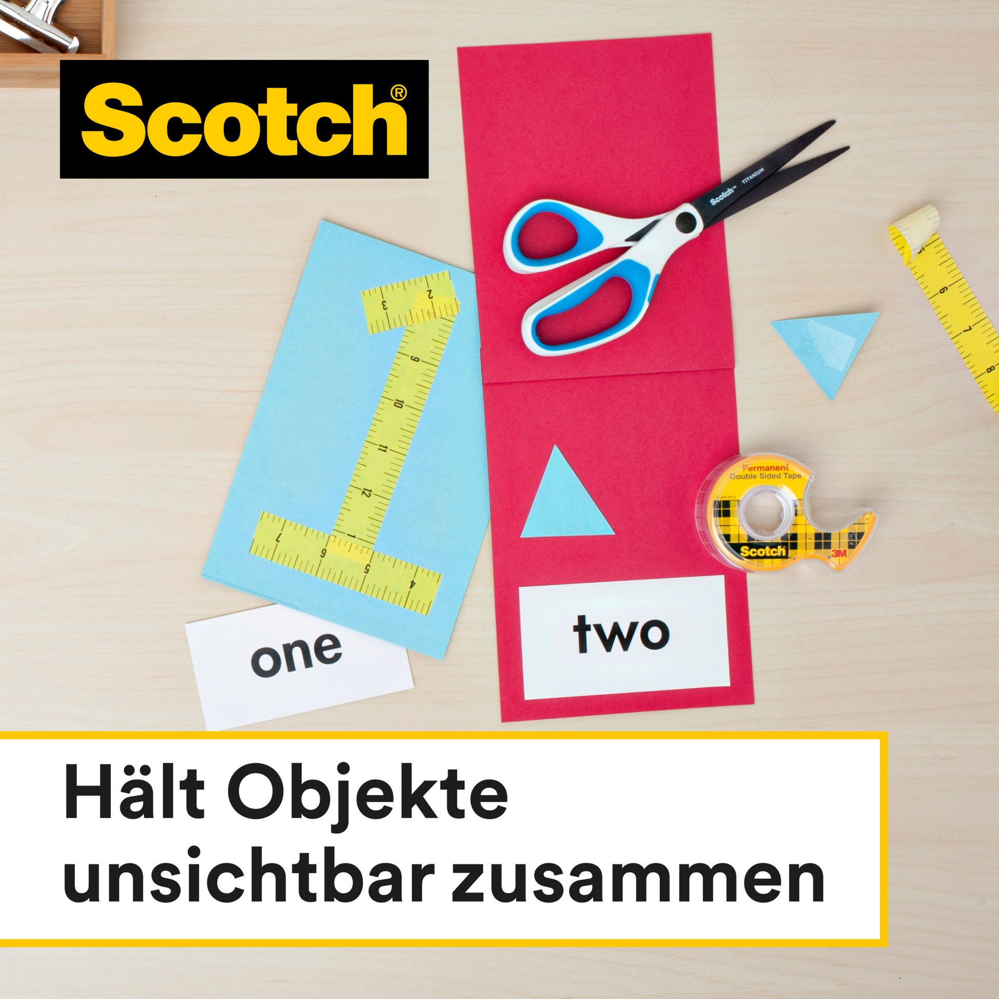 Eine Schere, ein Lineal, Papierformen und Karten mit der Aufschrift "eins" und "zwei" umgeben eine Rolle Scotch® doppelseitiges Klebeband (12 mm x 22,8 m) von 3M Deutschland GmbH auf einer hellen Holzfläche. Deutscher Text: "Hält Objekte unsichtbar zusammen.