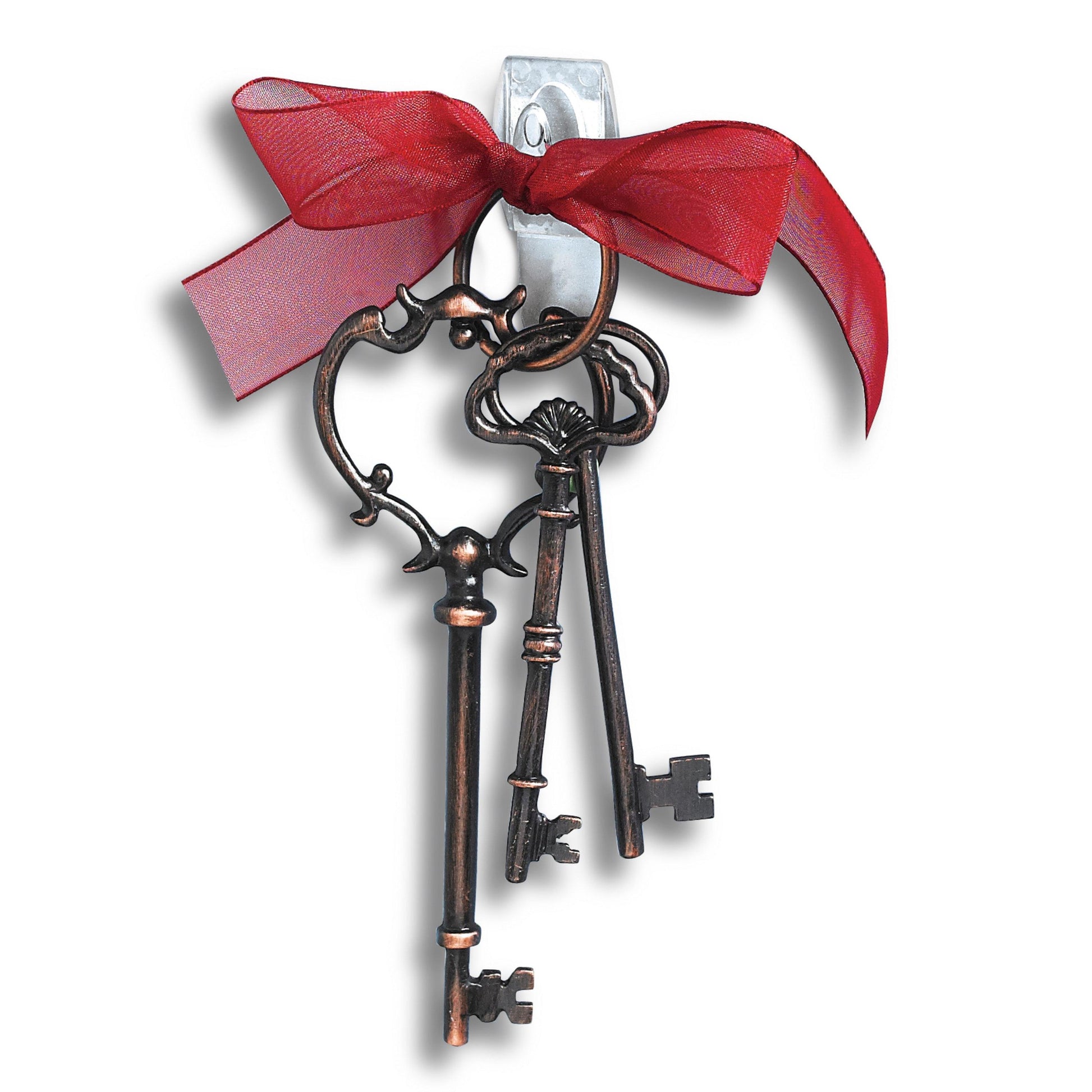 Drei verschnörkelte, antik anmutende Schlüssel an einem Schlüsselbund mit rotem Band hängen an einer weißen Wand mit 3M Deutschland GmbH Command™ Mini-Haken, transparent, mit transparenten Strips, 17006CLRFGN-perfekt für Aufbewahrung ohne Bohren.