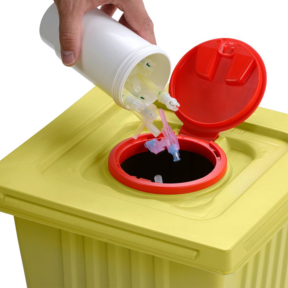 Eine Hand entsorgt gebrauchte Spritzenspitzen aus einem weißen Helmut Schwarz GmbH melijekt Entsorgungsbehälter 12 L in einen gelben Medizinabfallbehälter mit rotem Deckel und stellt so die ordnungsgemäße Entsorgung sicher.