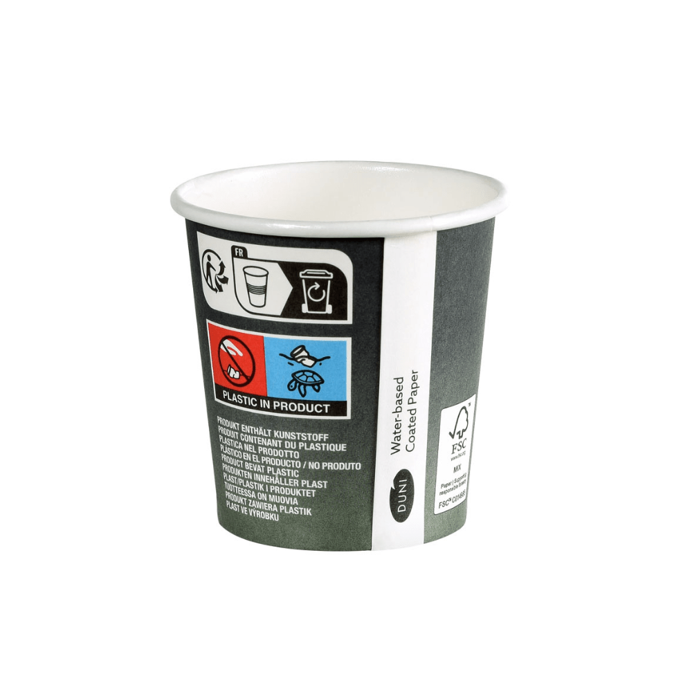 De Duni Urban Koffiebeker PAP/PLA Bedrukt van Duni GmbH is een kleine wegwerpbeker van karton met symbolen en tekst die wijzen op het kunststofgehalte. Hij beschikt over een logo met FSC-certificering, een doodshoofdsymbool en een tekst in verschillende talen die duurzaamheid voor wereldwijd begrip benadrukt.